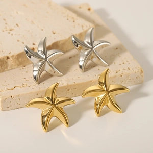18K gold and silver starfish stud earrings in stainless steel on stone background