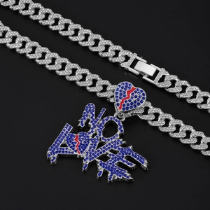 Close-up of silver Cuban chain with blue iced out NO LOVE pendant and red heart detail