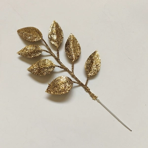 Macro shot of artificial Christmas glitter leaf spray in sparkling gold for DIY crafts