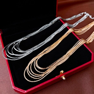 Elegant multi-layered gold and silver snake chain necklace on jewelry box display