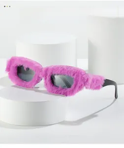 Detail of creative pink faux fur sunglasses with black square lenses on a white pedestal
