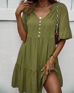 Détail de la robe vert olive à manches courtes, col en V, boutons et jupe à volants