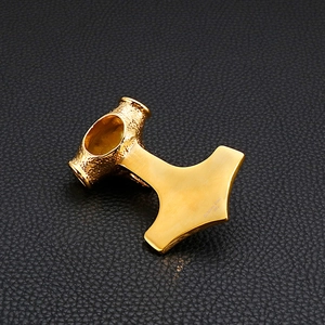 Détail du pendentif marteau en acier inoxydable 316L doré sur fond de cuir noir