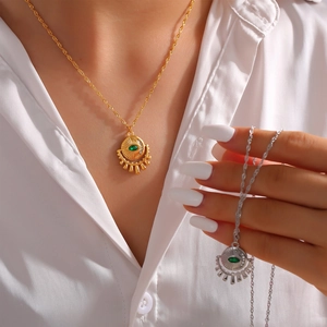 Gold and silver eye pendant necklace with green zircon inlay on wavy chain link