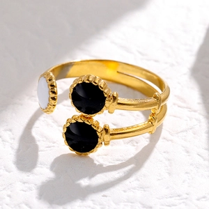 Detail of vintage gold-plated open ring with black and white drip oil circular charms