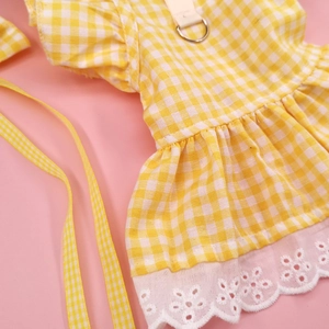 Detail of yellow gingham pet dress featuring floral lace trim and metal D-ring attachment