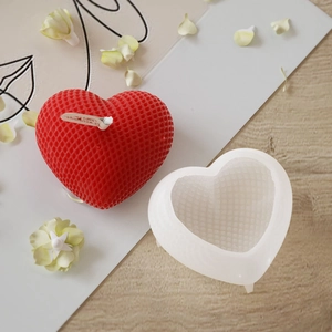 Vista macro dello stampo in silicone a forma di cuore e della candela rossa testurizzata