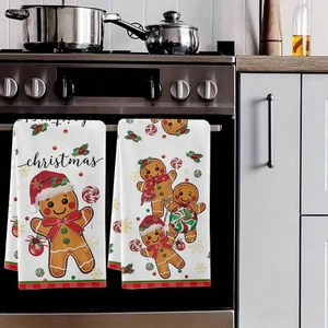 Weihnachtliche Küchentücher mit Lebkuchenmann-Motiven an der Ofenstange aufgehängt