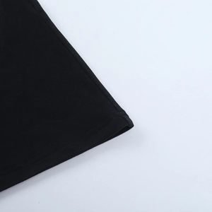 Close-up of double-stitched hem and fabric texture on a black off-shoulder dress