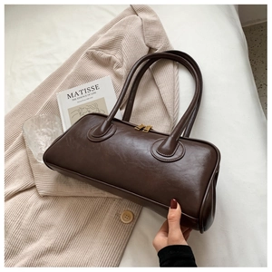 Detail of soft dark brown vintage hobo bag with round handles on a cozy aesthetic backdrop