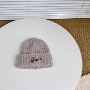 Detailed close-up of wool-blend knit beanie featuring black embroidered Pensecola letters