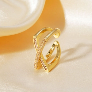 Luxurious gold-plated criss-cross ring with micro-pave zircons on soft silk background