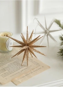 Close-up of a sparkling gold glittered star ornament hanging against a cozy holiday background