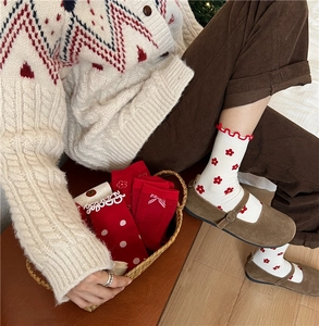 Detail of red and white cotton socks with floral patterns, polka dots and bow accents