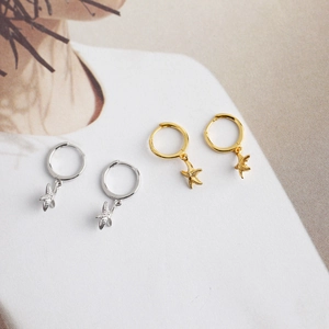 Detailed view of starfish pendant hoop earrings in both gold and silver finishes