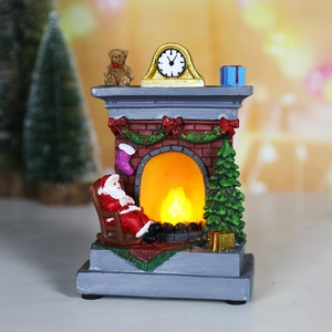 Detail of Santa Claus in rocking chair by glowing resin fireplace Christmas light decor