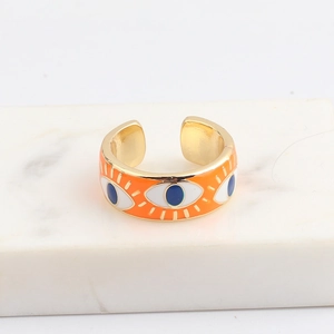 Detail of gold evil eye ring with orange enamel finish and smooth inner surface