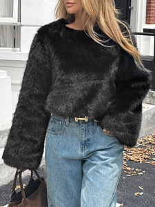 Elegante maglione nero in pelliccia sintetica da donna abbinato a jeans blu dritti