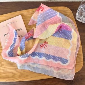 Detailed view of floral cotton linen headscarf with wave patterns and red bow accents