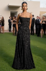 Detail of black evening maxi dress showing textured jacquard fabric and slim straps