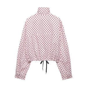 Rear view of pink polka dot jacket featuring high collar and adjustable drawstring hem