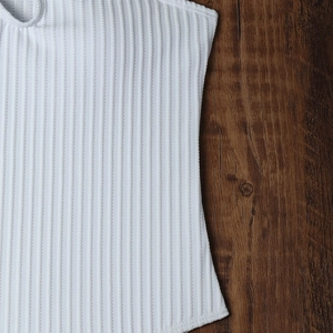 Macro shot of white ribbed knit fabric texture and side stitching for women swimwear