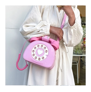 Detail shot of a pink vintage telephone shaped crossbody bag with dial pad decoration