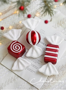 Close-up of red and white striped Christmas candy ornaments on a festive decorative background