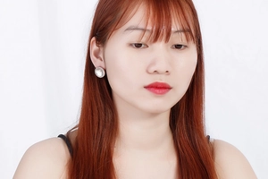 Detailed close-up of oval crystal earrings with rhinestone border worn by a model