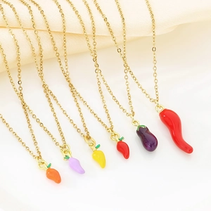 Detailed flat lay of colorful enamel vegetable charms on thin gold stainless steel chains