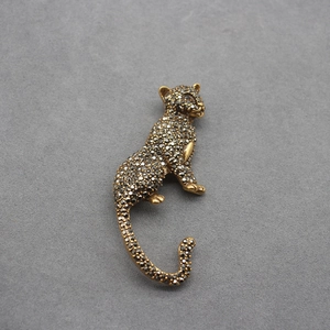 Vintage leopard brooch with black crystals and gold-tone finish in a classic seated pose