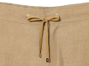 Close-up of khaki trousers with adjustable drawstring waist and gold metal tips