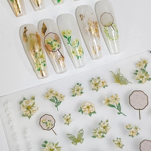 5D floral and butterfly nail art stickers with gold foil details on white coffin nails