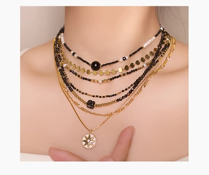 Detailed macro view of layered black spinel beads and gold necklace with starburst pendant