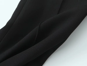 Close-up detail of high-quality black woven fabric texture for stirrup trousers