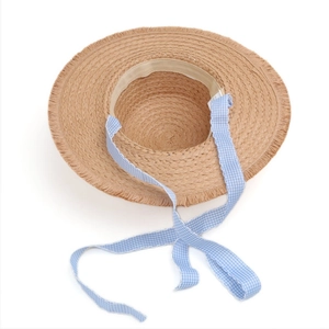 Detailaufnahme eines Damen-Strohhutes mit ausgefranstem Rand und blauem Karoband-Detail