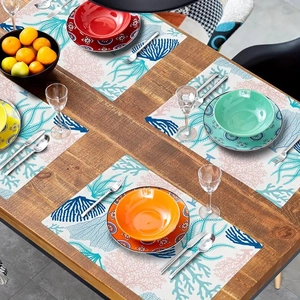 Detail of blue coral pattern placemat on dark wood table with colorful plates