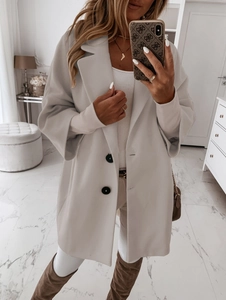 Détail d'un manteau en laine gris avec col à revers, coupe silhouette et boutons