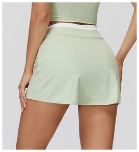 Dettaglio gonna-pantalone sportiva verde chiaro a vita alta con fascia bianca a coste