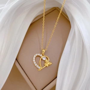 Golden titanium steel heart and butterfly necklace with pavé diamonds on beige display