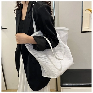 White mesh tote bag shown on a model with minimalist indoor background for fashion context