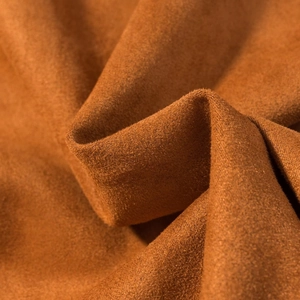 Vue macro du tissu en daim camel montrant la texture douce et le grain de la veste
