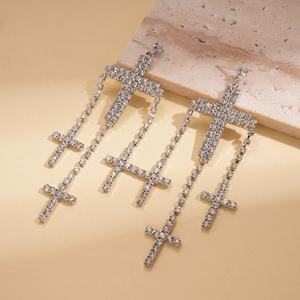 Macro shot of silver layered cross tassel earrings with sparkling rhinestones decoration