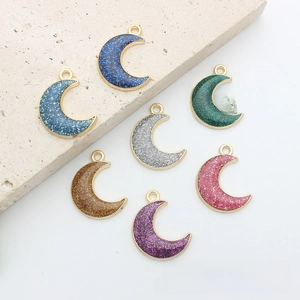 Macro detail of crescent moon pendants with colorful glitter and gold metal frames