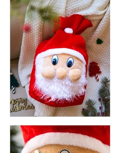 Détail du sac cadeau Père Noël en velours rouge sur couverture en maille blanche