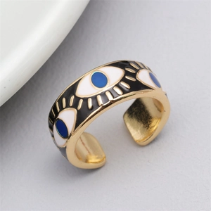 Macro shot of gold evil eye open ring featuring blue enamel details and textured finish