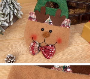 Detail of Christmas reindeer felt gift bag with green handles and red checkered antlers