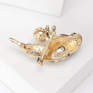Golden crystal enamel pearl animal brooch showing detailed back pin texture and structure