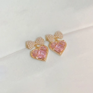 Orecchini a fiocco dorati con zircone a cuore rosa e perle su base avorio