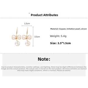 Detail view of bow earrings made of copper with faux pearls and zircons weighing 5.4g